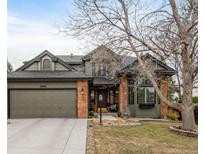 Charming two-story home featuring a brick and siding exterior, manicured landscaping, and an attached two-car garage at 19080 E Low Cir, Aurora, CO 80015
