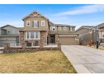 Attractive two-story home with a three-car garage, well-maintained lawn and stone accents on the facade at 17748 W 95Th Ave, Arvada, CO 80007