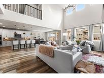 Spacious living room featuring high ceilings, natural light, an open floor plan, and stylish modern decor at 17748 W 95Th Ave, Arvada, CO 80007