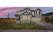 Beautiful two-story home with manicured lawn and modern architectural details at dusk at 6255 Kenzie Cir, Castle Pines, CO 80108