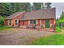 Charming single-Gathering home with a mix of wood and stone exterior, covered entry, and forested surroundings at 7559 S Turkey Creek Rd, Morrison, CO 80465