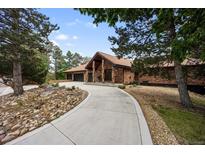 Stunning brick home featuring a three-car garage, tile roof, and meticulously maintained landscaping at 12570 W 60Th Ave, Arvada, CO 80004