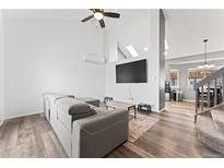 Bright living room featuring hardwood floors, modern furniture, and a vaulted ceiling at 12119 Forest St, Thornton, CO 80241