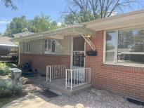 Charming brick home with a decorative metal awning over the front porch at 451 Lansing St, Aurora, CO 80010