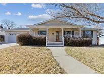 Ranch style home with front porch and landscaped lawn at 7447 Quay St, Arvada, CO 80003