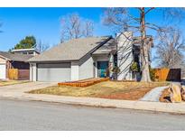 Charming single-Gathering home boasts a gray exterior, well-maintained lawn, and attached two-car garage at 6075 W Jefferson Ave, Denver, CO 80235