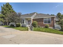 Charming single-story home with brick accents, manicured lawn, mature trees, and inviting entrance at 2265 S Depew St, Denver, CO 80227