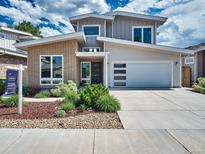 Contemporary two-story home featuring a brick accent, a two-car garage, and professional landscaping at 6096 W Keene Ave, Denver, CO 80235