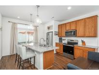 Bright, modern kitchen with granite countertops, stainless steel appliances, and a center island at 4431 N Quatar Ct, Aurora, CO 80019