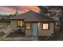 Charming single-story home featuring a welcoming front door and well-lit windows against a colorful sunset backdrop at 598 S Navajo St, Denver, CO 80223