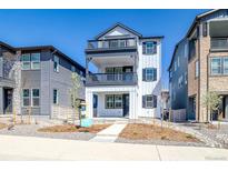 Charming three-story home featuring double balconies, a modern white facade, and professional landscaping at 8509 Orchard City Dr, Littleton, CO 80125