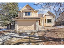 Charming two-story home featuring a large attached garage and inviting front yard with mature trees in a residential neighborhood at 7288 S Zephyr Way, Littleton, CO 80128