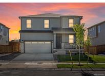 Charming two-story home with a well-manicured lawn, front porch, and two car garage at 8850 Sedalia St, Commerce City, CO 80022
