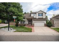 Charming two-story home with a well-manicured lawn, mature trees, and a two-car garage at 4501 Whitehall Ln, Highlands Ranch, CO 80126