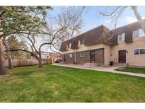 Inviting townhome with a well-manicured lawn and mature trees enhancing curb appeal at 7755 E Quincy Ave # T80, Denver, CO 80237