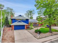 Charming two-story home with a well-manicured front yard and a painted blue trim at 12355 E Arkansas Pl, Aurora, CO 80012