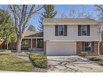 Charming two-story home with brick and white siding, complemented by a two-car garage and professionally landscaped yard at 7998 S Wabash Ct, Centennial, CO 80112
