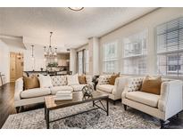 Bright living room featuring a tufted sofa and armchairs, and hardwood floors at 1200 Cherokee St # 206, Denver, CO 80204