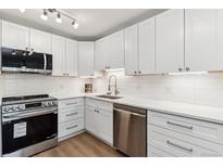 Modern kitchen with white cabinets, stainless steel appliances, and quartz countertops at 775 S Alton Way # 2C, Denver, CO 80247