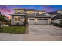 Beautiful two-story home featuring gray siding, stone accents, a three-car garage, and a well-manicured front lawn at 3091 Keepsake Way, Castle Rock, CO 80109