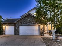 The exterior of this home is stone faced and includes a 3-car garage for plenty of parking space at 2010 Saddleback Dr, Castle Rock, CO 80104
