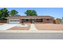 Charming single-story brick house with a well-maintained front yard, driveway, and attached garage at 209 S 13Th Ave, Brighton, CO 80601