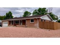 Charming brick home featuring a well-maintained lawn and attached garage at 209 S 13Th Ave, Brighton, CO 80601
