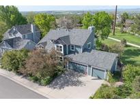An elevated view of a home with a gray roof, two-car garage and mature landscaping around the property at 902 Grove Dr, Louisville, CO 80027