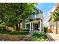 Charming two-story home with a manicured front yard and a beautiful mature tree at 1429 Josephine St, Denver, CO 80206