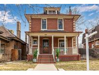 Charming two-story red brick home with a covered front porch and classic architectural details at 1052 Milwaukee St, Denver, CO 80206