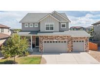 Charming two-story home with brick accents, gray siding, and a well-maintained lawn at 1315 Sidewinder Cir, Castle Rock, CO 80108