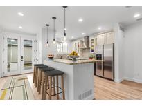 Modern kitchen with granite countertops, stainless steel appliances, and an eat-in island with barstool seating at 3322 W 26Th Ave, Denver, CO 80211