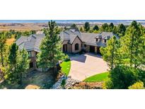 Beautiful home featuring lush landscaping, a paved driveway, and a tile roof in an upscale neighborhood at 770 International Isle Dr, Castle Rock, CO 80108