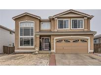 Inviting two-story home featuring a two-car garage, well-maintained lawn and beautiful curb appeal at 9606 Adelaide Cir, Highlands Ranch, CO 80130