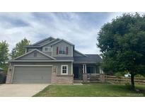 Charming two-story home with a well-maintained lawn and a two-car garage at 136 Wiggett Ct, Erie, CO 80516