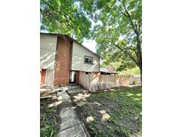 Charming brick and siding exterior with mature trees and a wooden fence at 64 Nome Way # C, Aurora, CO 80012