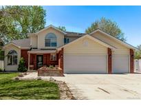 Charming home with red brick accents, three-car garage, and a well-maintained lawn and garden at 105 Hawthorn St, Frederick, CO 80530