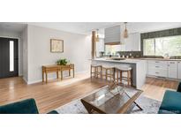 Bright, open kitchen boasts a large island with seating and modern appliances at 3089 S Jasmine St, Denver, CO 80222