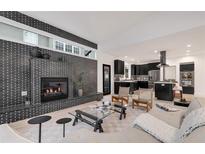 Open-concept living room with brick fireplace, modern decor, and seamless flow to the kitchen at 520 Columbine St, Denver, CO 80206