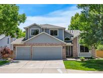 Charming two-story home boasts a three-car garage, well-manicured lawn, and mature trees at 7900 E Iowa Ave, Denver, CO 80231