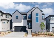 Modern two-story home featuring sleek gray siding, a black garage door, and a well-manicured front yard at 11324 Alla Breve Cir, Lone Tree, CO 80134