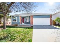 Charming single Gathering home featuring blue siding, a two-car garage, and a well-manicured front lawn at 1444 S Richfield Way, Aurora, CO 80017