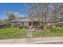 Charming brick home with a well-manicured lawn, mature trees, and inviting stone pathway at 2991 S Fillmore Way, Denver, CO 80210