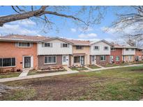 A row of brick and painted townhomes with small front yards and walkways on a partly cloudy day at 12661 W Alameda Dr, Lakewood, CO 80228