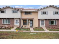 Classic townhome featuring brick facade, covered entryway, and tidy front garden at 12661 W Alameda Dr, Lakewood, CO 80228