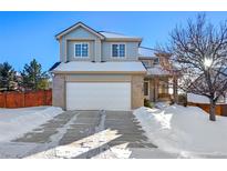 Two-story house with a white garage door and snow-covered driveway at 600 Balsa Dr, Castle Rock, CO 80104