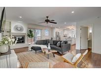 Bright living room with hardwood floors, a fireplace, and a comfortable gray sectional sofa at 3434 S Race St, Englewood, CO 80113