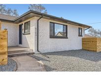 Modern home exterior features a gray brick facade, dark trim, and freshly graveled front yard at 5103 W 36Th Ave, Denver, CO 80212