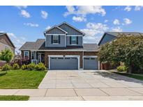 Charming two-story home with a brick facade, well-maintained lawn, and a spacious three-car garage at 25850 E 3Rd Ave, Aurora, CO 80018