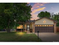 Charming single-Gathering home featuring a well-manicured lawn and an attached two-car garage at dusk at 5991 W 68Th Ave, Arvada, CO 80003